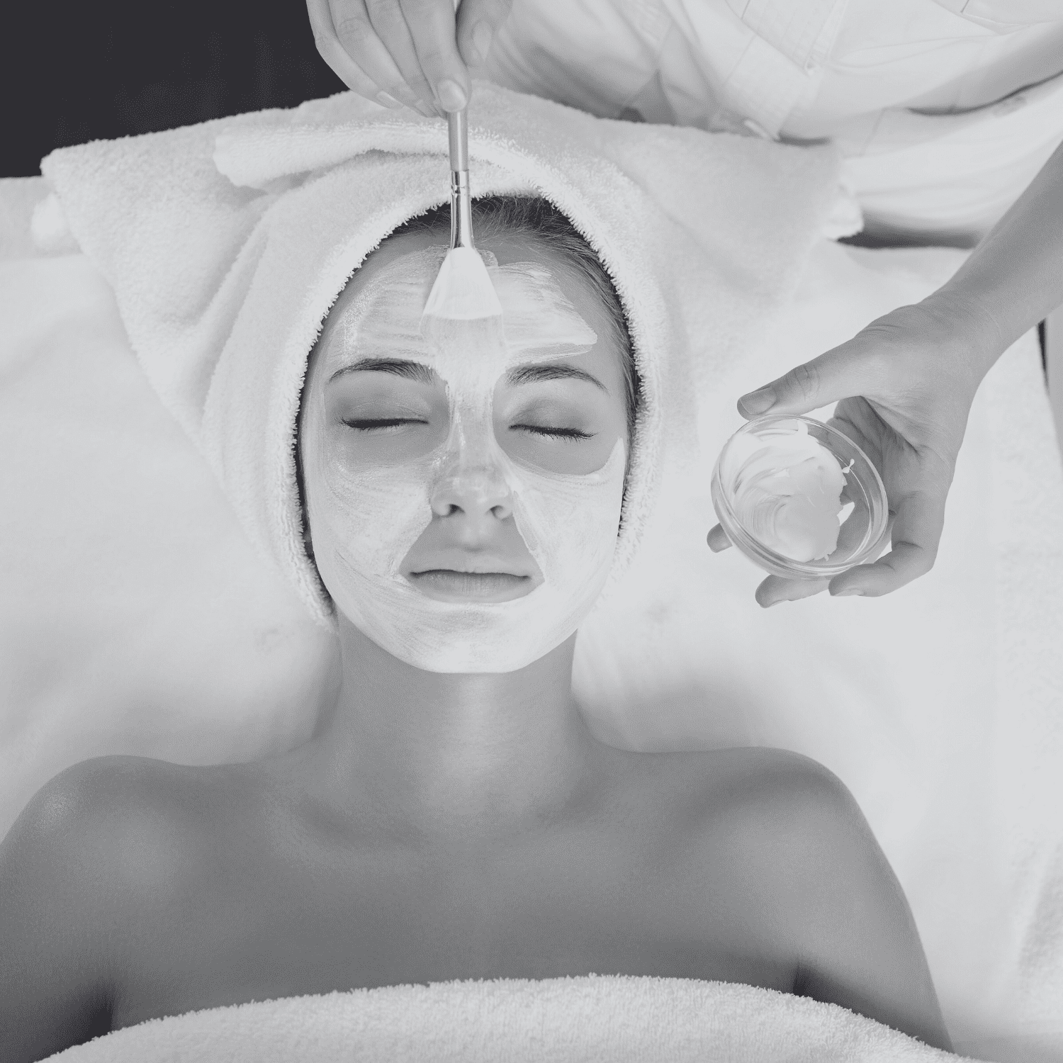 Facial spa treatment with mask application on relaxed woman.
